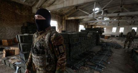 Un soldado ucraniano junto a cajas de municiones abandonadas por las fuerzas rusas en retirada en la aldea de Blahodatne, en la región ucraniana de Jersón, el 11 de noviembre de 2022.