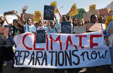 SHARM EL SHEIKH, EGYPT - NOVEMBER 11: Young protesters demanding climate reparations payment from rich countries to poor countries impacted by climate loss and damage march at the conference venue during the UNFCCC COP27 climate conference on November 11, 2022 in Sharm El Sheikh, Egypt. The conference is bringing together political leaders and representatives from 190 countries to discuss climate-related topics including climate change adaptation, climate finance, decarbonisation, agriculture and biodiversity. The conference is running from November 6-18. (Photo by Sean Gallup/Getty Images)