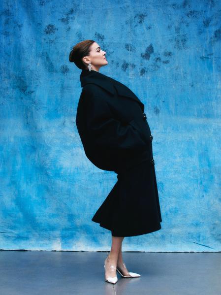 Con maxiabrigo de lana y stilettos de vinilo y corazones blancos 
de piel de Alaïa; pendientes Serpenti Skin de Bulgari