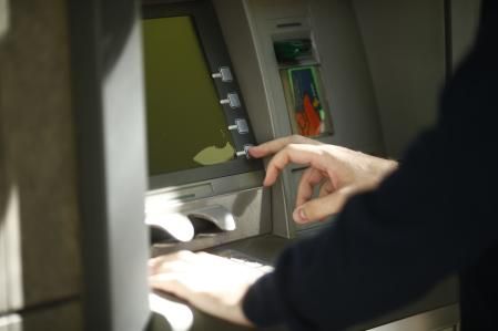 Un usuario de banca sacando dinero de un cajero