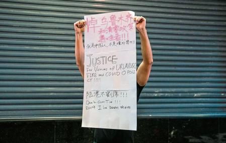 A demonstrator holds a sign during a vigil commemorating victims of China's Covid Zero policy in Hong Kong, China, on Monday, Nov. 28, 2022. Dozens of people in Hong Kong rallied in the city and emulated some of the protests erupting in China in opposition to the nation#{emoji}146;s Covid Zero policy. Photographer: Lam Yik/Bloomberg