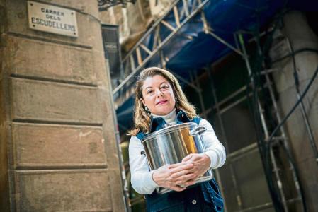 a gastrónoma Inés Butrón en la calle Escudellers, donde nació, sujetando la olla en que cocinará para el 25 de diciembre