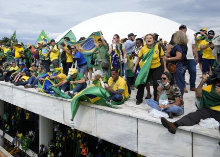 Manifestantes partidarios de Jair Bolsonaro se paran en el techo del edificio del Congreso Nacional después de asaltarlo en Brasilia, Brasil, el 8 de enero del 2022