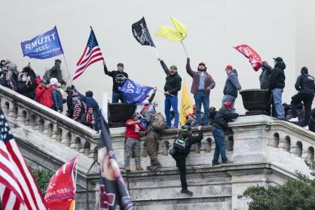 Los insurrectos leales al expresidente Donald Trump se paran en las escaleras hacia un balcón en el frente oeste del Capitolio de los EE.UU. el 6 de enero de 2021 en Washington