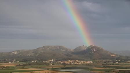 Arco iris emergiendo de la cima de la montaña.