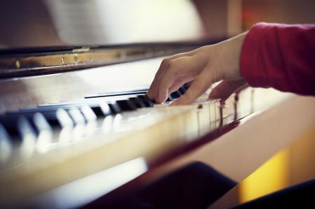 Close-up image of a girl playing the piano.