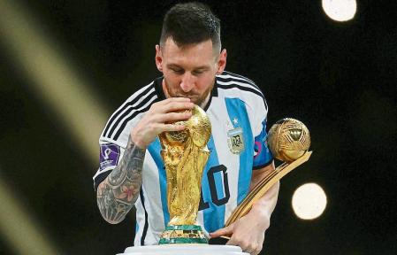 FILE PHOTO: Soccer Football - FIFA World Cup Qatar 2022 - Final - Argentina v France - Lusail Stadium, Lusail, Qatar - December 18, 2022 Argentina's Lionel Messi kisses the World Cup trophy after receiving the Golden Ball award as he celebrates after winning the World Cup REUTERS/Kai Pfaffenbach/File Photo