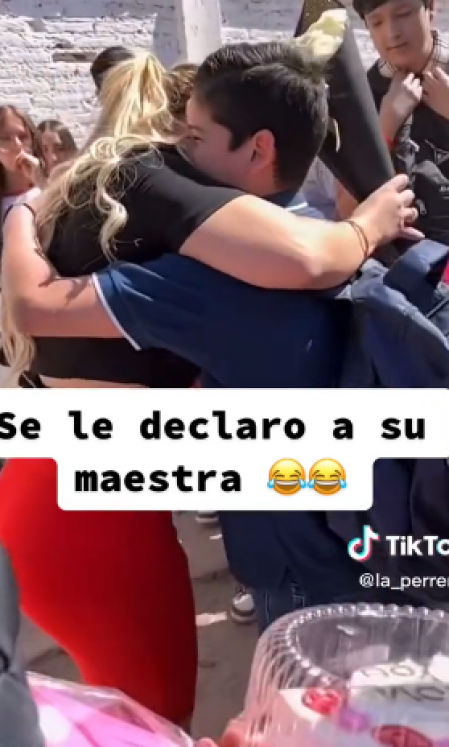 Maestra y alumno se abrazan