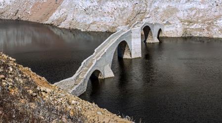Vista del puente de Querós, reaparecido por la sequía en el pantano de Susqueda.