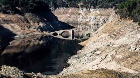 Vista del puente de Querós, reaparecido por la sequía en el pantano de Susqueda.