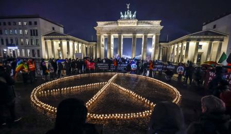 Berlin (Germany), 23/02/2023.- People stand around a peace sign made of candles in front of the Brandenburg Gate in Berlin, Germany, 23 February 2023. It is part of different actions on the first anniversary of the Russian invasion of Ukraine. Russian troops entered Ukrainian territory on 24 February 2022, starting a conflict that has provoked destruction and a humanitarian crisis. One year on, fighting continues in many parts of the country. (Alemania, Rusia, Ucrania) EFE/EPA/HANNIBAL HANSCHKE