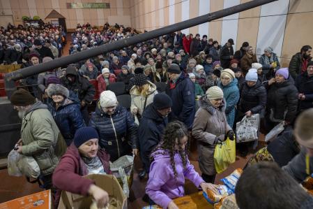 Ciudadanos ucranianos reciben ayuda alimentaria en una iglesia habilitada como centro de ayuda humanitaria