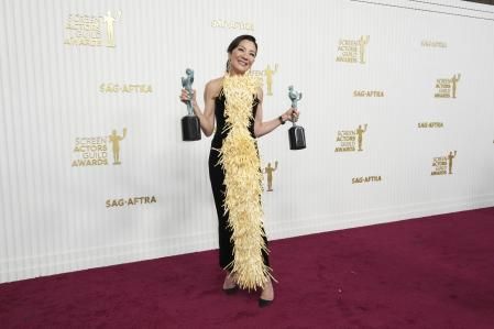 Michelle Yeoh posa con sus premios en la alfombra roja de los SAG Awards