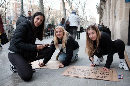 Tres chicas ultiman sus pancartas