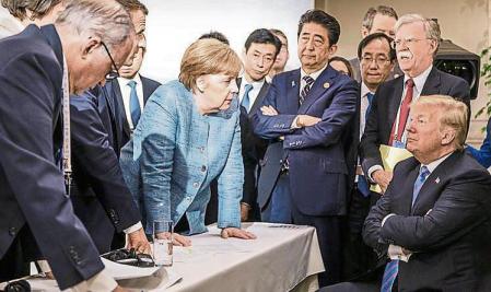 2018 Year In Focus News CHARLEVOIX, CANADA - JUNE 9: In this photo provided by the German Government Press Office (BPA), German Chancellor Angela Merkel deliberates with US president Donald Trump on the sidelines of the official agenda on the second day of the G7 summit on June 9, 2018 in Charlevoix, Canada. Also pictured are (L-R) Larry Kudlow, director of the US National Economic Council, Theresa May, UK prime minister, Emmanuel Macron, French president, Angela Merkel, Yasutoshi Nishimura, Japanese deputy chief cabinet secretary, Shinzo Abe, Japan prime minister, Kazuyuki Yamazaki, Japanese senior deputy minister for foreign affairs, John Bolton, US national security adviser, and Donald Trump. Canada are hosting the leaders of the UK, Italy, the US, France, Germany and Japan for the two day summit. (Photo by Jesco Denzel /Bundesregierung via Getty Images)