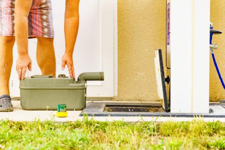 Hombre vaciando cassette de inodoro del tanque de la caravana en la estación de descarga