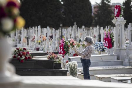 Una mujer coloca flores en una de las lápidas del Cementerio de San Fernando, en Sevilla, Andalucía (España), a 28 de octubre de 2020. El 1 de noviembre, Día de Todos los Santos, los cementerios son visita obligada para muchos españoles, que acuden a los camposantos de su localidad o a donde descansan los restos de sus familiares para depositar flores en sus tumbas. Este año, marcado por el coronavirus, numerosas ciudades han impulsado una serie de medidas para evitar aglomeraciones en los cementerios, pero sin dejar el servicio de visitas durante la segunda ola de la pandemia. El Cementerio de San Fernando fue construido a lo largo del año 1852 y abrió sus puertas al primer entierro el día 1 de enero de 1853.En las vías principales se encuentran las tumbas, mausoleos o monumentos funerarios de toreros, guitarristas, poetas, escultores, políticos, deportistas, cantaores y cantaoras, entre ellos destacan los de Joselito 