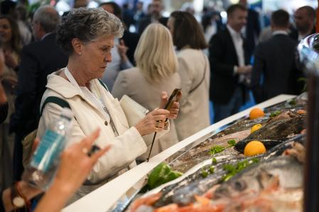 Una visitante observando un producto en la feria Seafood