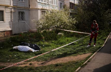 Un trabajador de emergencia se encuentra cerca de cadáveres en bolsas de plástico cerca del sitio de un edificio residencial gravemente dañado alcanzado por un misil ruso, en medio del ataque de Rusia contra Ucrania, en la ciudad de Uman, región de Cherkasy, Ucrania