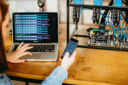 Una mujer viendo el precio de una moneda digital en un portátil