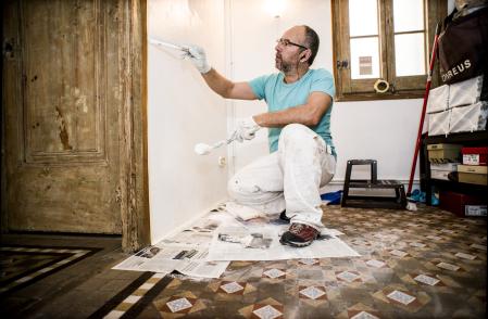 foto XAVIER CERVERA 27/12/2017 un pintor (trabajador autonomo) en su profesion laboral en un piso del eixample, barcelona, pintando -tras masillar- una pared blanca con problemas previos de humedad, utilizando herramientas varias