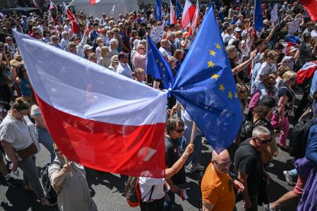 WARSAW, POLAND – JUNE 04: Supporters of opposition parties hold European Union, Polish flags and banners during the Freedom march organized by the main opposition party, Civil Platform leader Donald Tusk on June 04, 2023 in Warsaw, Poland. June 04th is a symbolic date commemorating the first round of partially free parliamentary elections after the fall of communism in Poland. Polish Parliament (SEJM) recently voted on a controversial law to build a commission to investigate Russian influence in Poland, empowering bans on individuals from public office for up to ten years.  The US and EU have raised concerns with the new law and many experts and opposition figures point out that the law, nicknamed 