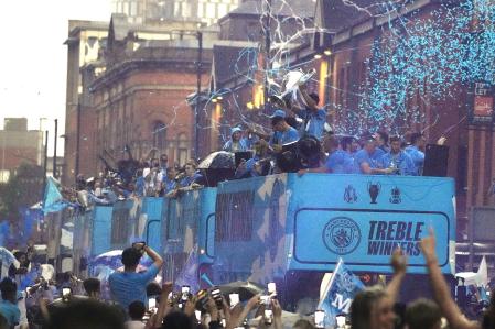 Manchester City soccer players celebrate winning the triple, Premier League, FA-Cup and Champions League, in a trophy parade in Manchester, England, Monday, June 12, 2023.(AP Photo/Jon Super))