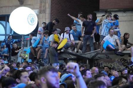 Manchester City soccer supporters cheer during the Treble Parade in Manchester, England, Monday, June 12, 2023. Manchester City completed the treble (Champions League, Premier League and FA Cup) after a 1-0 victory over Inter Milan in Istanbul, securing Champions League glory. (AP Photo/Jon Super)