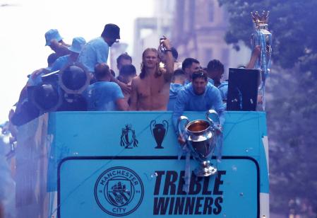 Soccer Football - Manchester City Victory Parade - Manchester, Britain - June 12, 2023 Manchester City's John Stones is pictured holding the Champions League trophy alongside Erling Braut Haaland and teammates during the parade REUTERS/Phil Noble