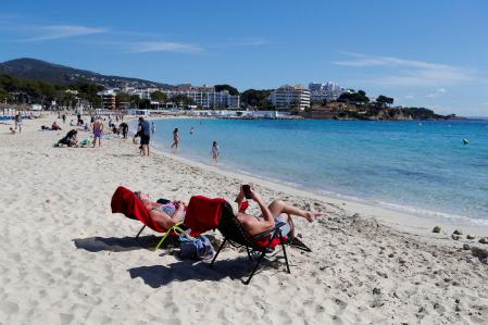 FILE PHOTO: People enjoy the sunny weather on Magaluf beach, on the Balearic island of Mallorca, Spain April 6, 2023. REUTERS/Enrique Calvo/File Photo