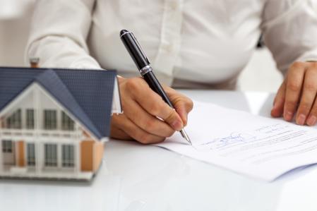 Un propietario de una vivienda firmando un contrato de alquiler de su vivienda