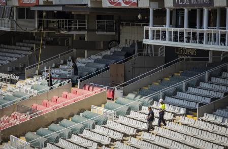 Varios operarios acondicionan las gradas de las instalaciones del Estadi Olímpic Lluís Companys