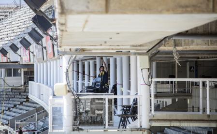 Varios operarios acondicionan las gradas de las instalaciones del Estadi Olímpic Lluís Companys