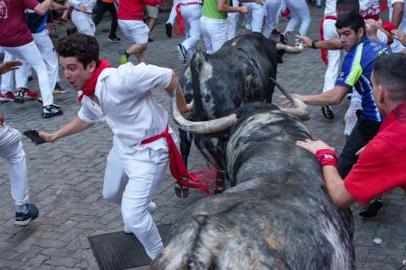 Participants run ahead of bulls during the 