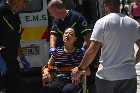 Una mujer es atendida por los servicios médicos por las altas temperaturas registradas este viernes en el Acrópolis de Grecia