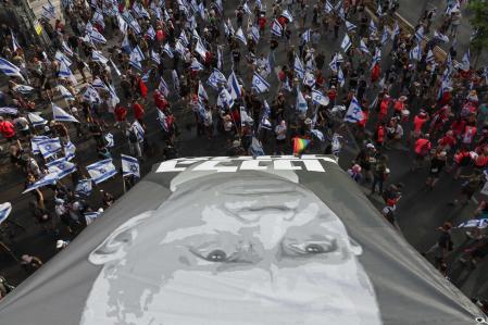 TOPSHOT - Demonstrators lift a large banner as they stage a 'day of resistance' to protest the Israeli government's judicial overhaul bill, in Tel Aviv on July 18, 2023. The proposals have divided the nation and triggered one of the biggest protest movements in Israel's history since being unveiled in January by the hard-right government of Prime Minister Benjamin Netanyahu. (Photo by JACK GUEZ / AFP)