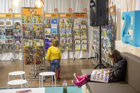 FOTO: MANÉ ESPINOSA. SETMANA LLIBRE EN CATALÀ. DOS NIÑOS LEEN COMICS DE CAVALL FORT EN UN EXPOSITOR DE LA FERIA.