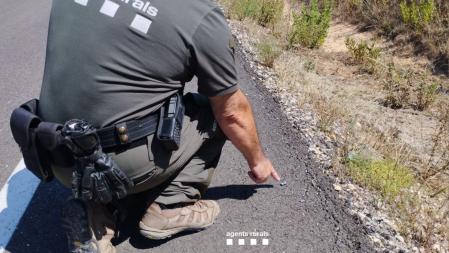 Un agente rural señala el trozo de un catalizador hallado en una zona donde se produjo un pequeño incendio forestal