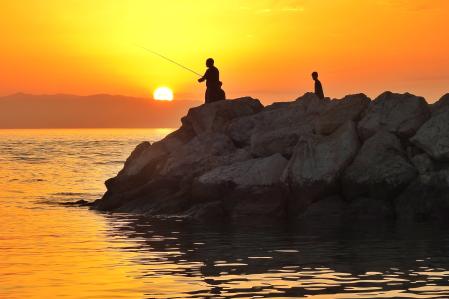 Personas pescando al amanecer en Fuengirola.