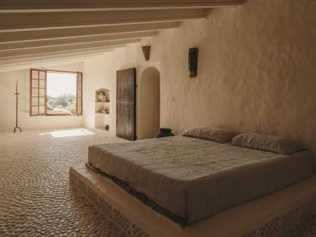 En los dormitorios, el pavimento es de cantos rodados. La cama descansa sobre una base de obra con celosía retroiluminada