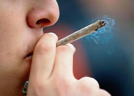 A man smokes a joint during a demonstration for the decriminalization of cannabis in France, in Paris on May 12, 2018. Some 1,300 people, according to the police, marched today in Paris for the decriminalization of cannabis in France, which 