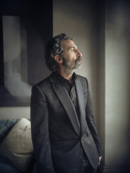 Camisa negra, americana con solapa y pantalón de corte cigarette, con detalles Monogram