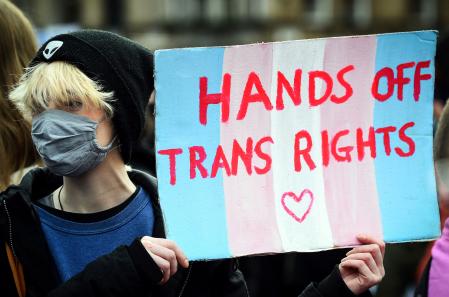 A Trans Rights activist holds a placard while taking part in the 