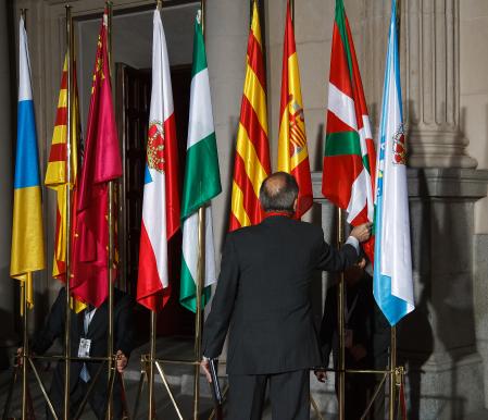 Unos operarios colocan las banderas de las comunidades autónomas