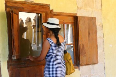 Visitante del monasterio de Pedralbes resguardándose del sol con el sombrero.