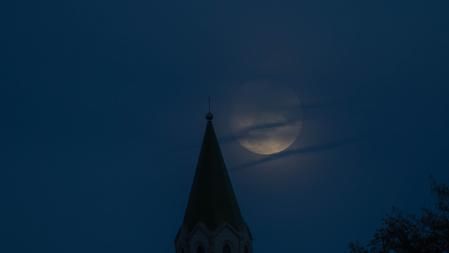 Luna casi llena en el campanario del santuario de Puig-agut.