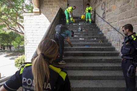 De limpieza. Policías escoltan a los barrenderos que recogen jeringuillas en los jardines Rubió i Lluch