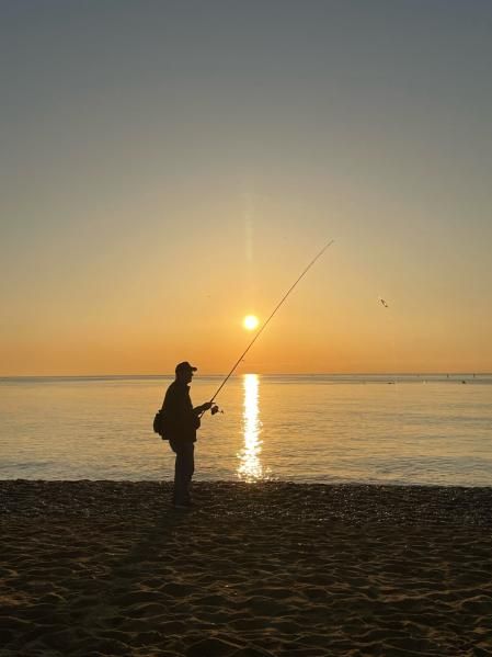 Pilar solar en el Mediterráneo iluminando al pescador de la Barceloneta.