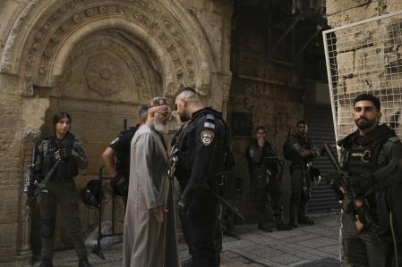 Israeli policeman questions a Palestinian worshipper on his way to pray at al-Aqsa mosque in Jerusalem, Friday, Oct. 13, 2023. (AP Photo/Maya Alerruzzo)