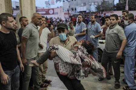 Un hombre lleva a un niño herido en un hospital de Khan Younis tras un bombardeo israelí, en el sur de la Franja de Gaza.
